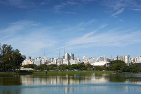 Skyline de São Paulo visto do Parque Ibirapuera, com prédios ao fundo refletidos no lago Skyline de São Paulo visto do Parque Ibirapuera, com prédios ao fundo refletidos no lago