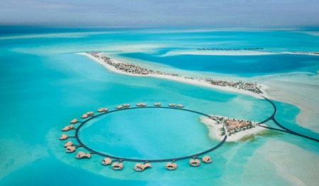 Vista aérea de resort de luxo nas Maldivas com bangalôs em formato circular sobre a água turquesa; CR7 é dono de duas vilas no local Vista aérea de resort de luxo nas Maldivas com bangalôs em formato circular sobre a água turquesa; CR7 é dono de duas vilas no local