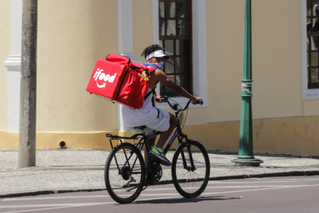 Trabalhador em bicicleta e mochila do iFood Trabalhador em bicicleta e mochila do iFood