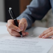 Homem assina contrato. Imagem remete a contrato de compra e venda ou contrato de locação ou aluguel de imóveis. Homem assina contrato. Imagem remete a contrato de compra e venda ou contrato de locação ou aluguel de imóveis.