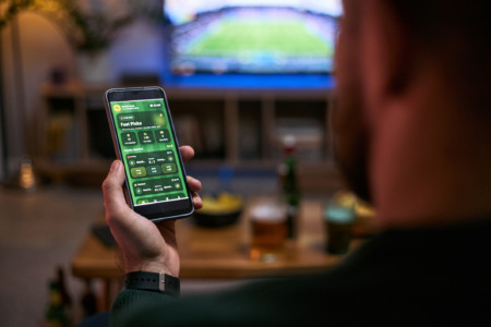 Homem joga no celular, com imagem de futebol ao fundo; saiba qual o impacto da proibição das bets no mercado imobiliário Homem joga no celular, com imagem de futebol ao fundo; saiba qual o impacto da proibição das bets no mercado imobiliário