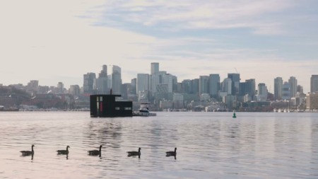 Casa flutuante Blatto Boat, do escritório GO''C, ancorada no Lago Union em Seattle, com o horizonte da cidade ao fundo Casa flutuante Blatto Boat, do escritório GO''C, ancorada no Lago Union em Seattle, com o horizonte da cidade ao fundo