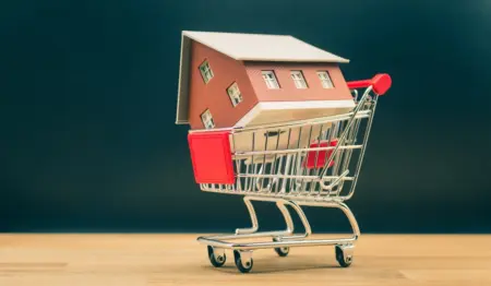 Carrinho de compras levando casa, remetendo à ideia de compra de imóveis, aquisição da casa própria. Carrinho de compras levando casa, remetendo à ideia de compra de imóveis, aquisição da casa própria.