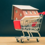 Carrinho de compras levando casa, remetendo à ideia de compra de imóveis, aquisição da casa própria. Carrinho de compras levando casa, remetendo à ideia de compra de imóveis, aquisição da casa própria.