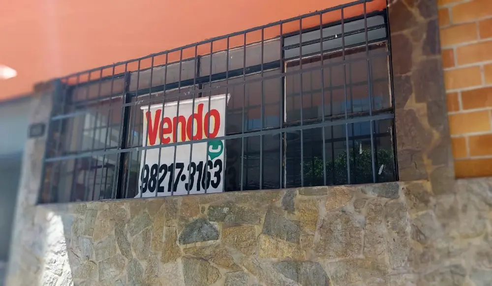 Placa de "Vendo" em janela de imóvel. Placa de "Vendo" em janela de imóvel.