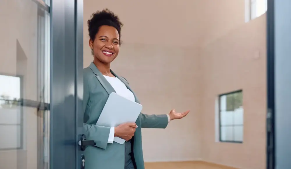 Corretora de imóveis dando as boas vindas a alguém na porta de um imóvel. Corretora de imóveis dando as boas vindas a alguém na porta de um imóvel.