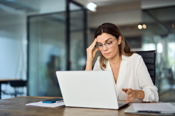 mulher olhando para o computador preocupada