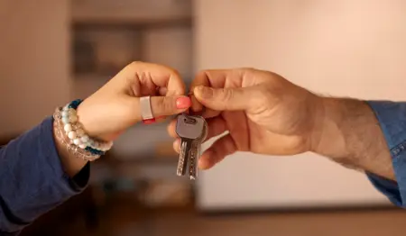 Mão de mulher passa chave de casa para mão de homem. Mão de mulher passa chave de casa para mão de homem.