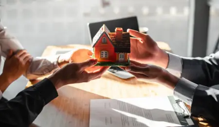 Imagem mostra pessoa entregando miniatura de casa para outras pessoas, remetendo à ideia de cessão de direitos sobre um imóvel, por exemplo. Imagem mostra pessoa entregando miniatura de casa para outras pessoas, remetendo à ideia de cessão de direitos sobre um imóvel, por exemplo.