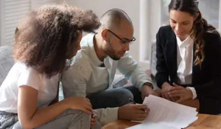 Homem verifica documentos de contrato ao lado de duas mulheres, remetendo à imagem de fiador em contrato de aluguel. Homem verifica documentos de contrato ao lado de duas mulheres, remetendo à imagem de fiador em contrato de aluguel.