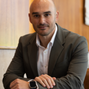 Gustavo Favaron, CEO Global do GRI Institute, sorrindo sentado à mesa
