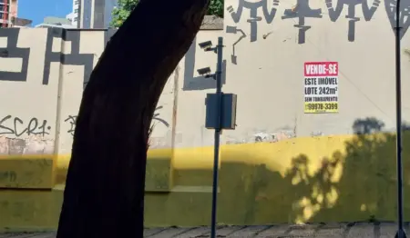 Placa de "vende-se" afixada em muro de imóvel comercial. Placa de "vende-se" afixada em muro de imóvel comercial.