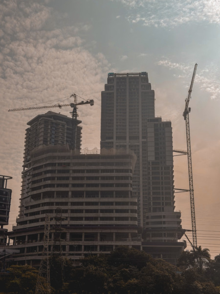 Prédios em construção com guindastes ao entardecer em São Paulo